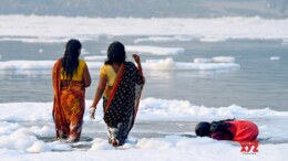 Noida: Devotees perform rituals in the river Yamuna as toxic foam seen floating during 'Nahaye Khaye puja' on the occasion of the Chhath Puja festival in Noida on Tuesday, November 05, 2024. (Photo: IANS)