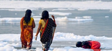 Noida: Devotees perform rituals in the river Yamuna as toxic foam seen floating during 'Nahaye Khaye puja' on the occasion of the Chhath Puja festival in Noida on Tuesday, November 05, 2024. (Photo: IANS)